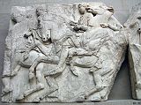 British Museum Top 20 04-1 Elgin Marbles Block 37 4. Parthenon Horsemen block number 37  Athens Parthenon, 447-432BC. The Elgin Marbles refers to the collection of sculptures from the Parthenon acquired by Lord Elgin between 1801 and 1805. The Parthenon was built as a temple to Athena on the Acropolis of Athens and was decorated with marble sculptures representing scenes from Athenian cult and mythology. This block from the north frieze shows three horsemen holding the reins of their galloping horses tightly in both hands. The first at the left wears a short chiton, chlamys and sandals, the second a double-belted sleeved chiton and sandals, whereas the body of the third at the join of the two blocks is badly damaged.